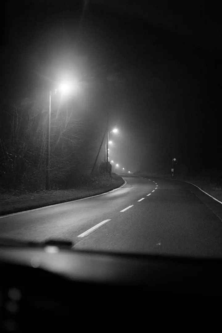 Nächtliche Straße im Nebel mit Straßenlaternen – klassische Lowlight-Situation, in der Bildrauschen entsteht