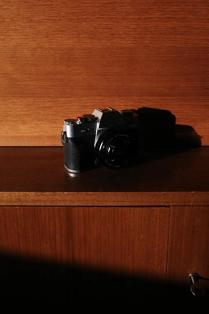 Fujifilm-Kamera mit kompakter 27-mm-Festbrennweite auf einem Sideboard