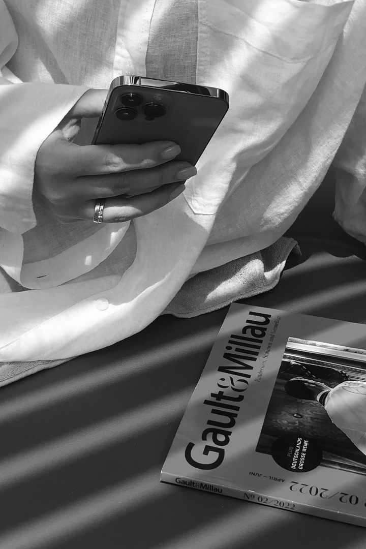 Bildausschnitt einer Frau mit einem iPhone in der Hand in schwarz-weiß