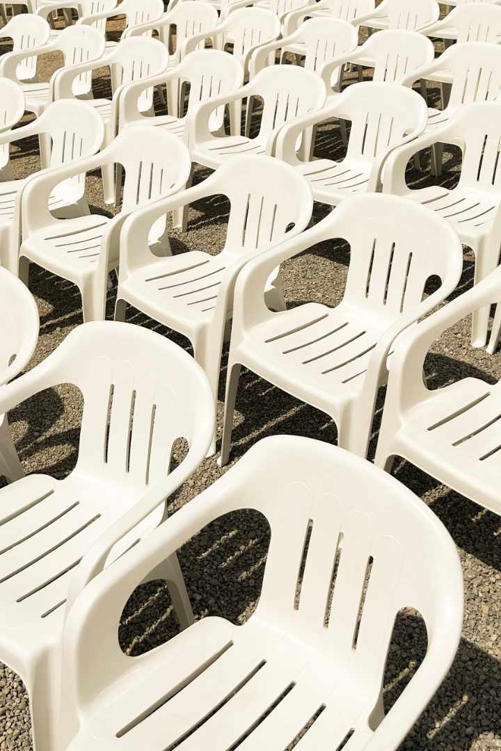 weiße Monobloc Stühle stehen in einer Reihe